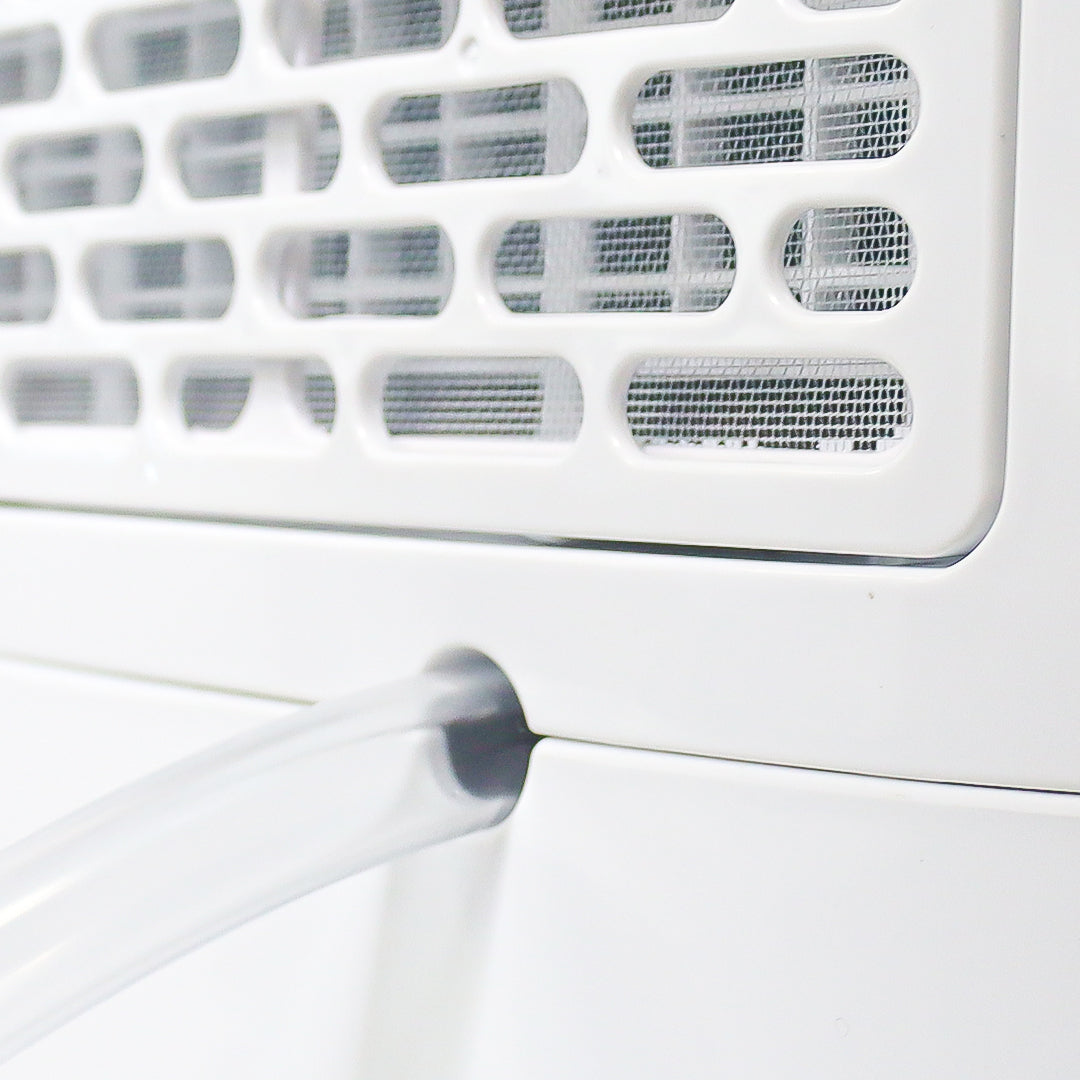 Close-up of a white air conditioner with a focus on the filter and fan.