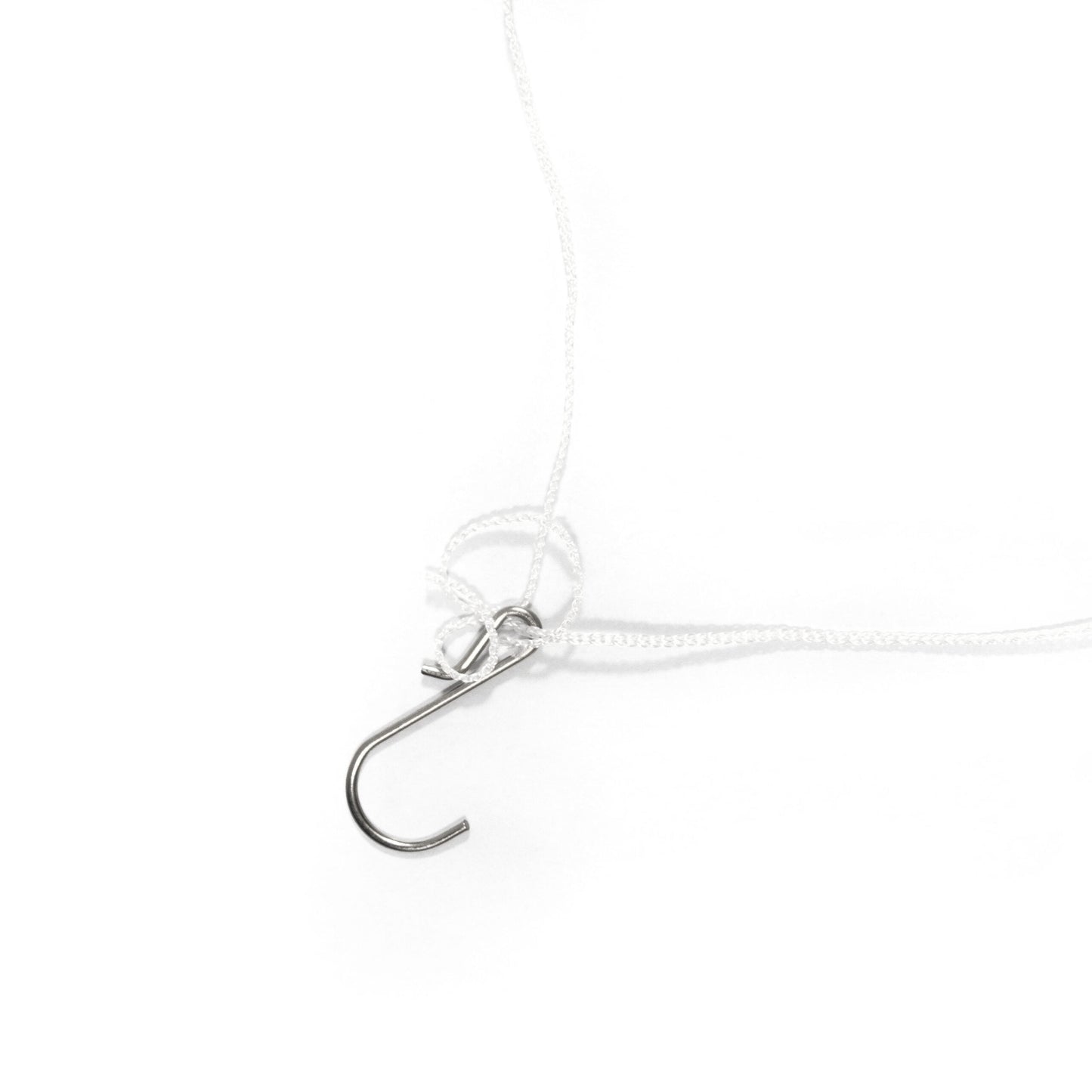 Close-up of a silver hook on a white background