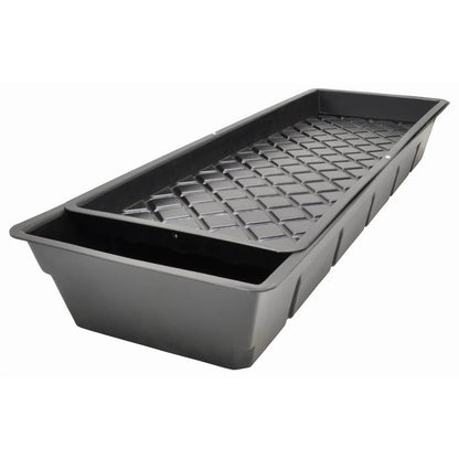 Black plastic seedling tray with drainage holes on a white background
