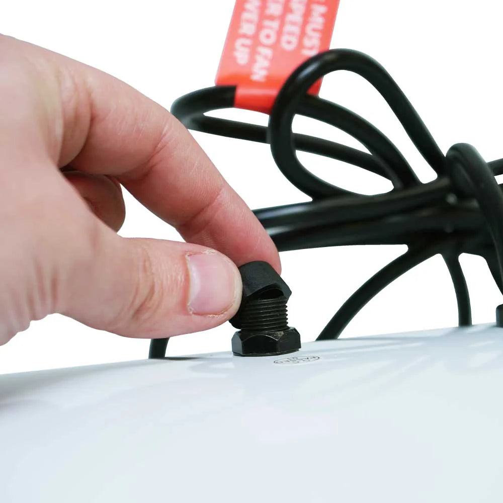 Hand tightening a black screw on a white object with a red label in the background